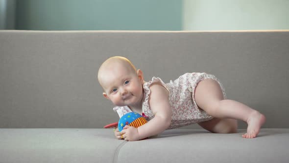 Cheerful Baby Girl Playing With Colorful Toys on Sofa, Infant Learning to Crawl