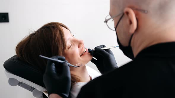 Closeup of a Young Woman with Braces Receiving Treatment in a Dental Office