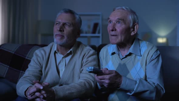 Senior Male Friends Switching Channels, Leisure Evening Time at Nursing Home