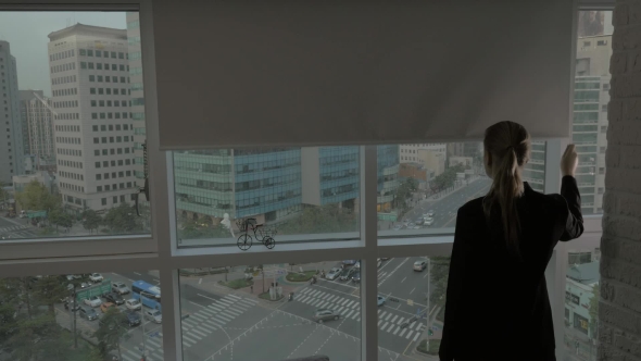 Woman Opening Window Blind And Looking At Seoul City, South Korea