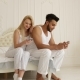 Couple Using Smart Phone Sitting Bed Mix Race Man Woman Embrace Smile Morning Bedroom - VideoHive Item for Sale