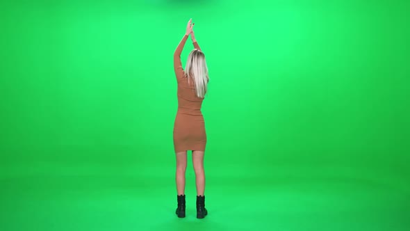 Back View Woman Dancing at a Music Concert Dance and Swing Their Arms on a Green Background