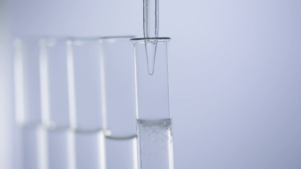 Pipette Drips Transparent Water Into a Test Tubes