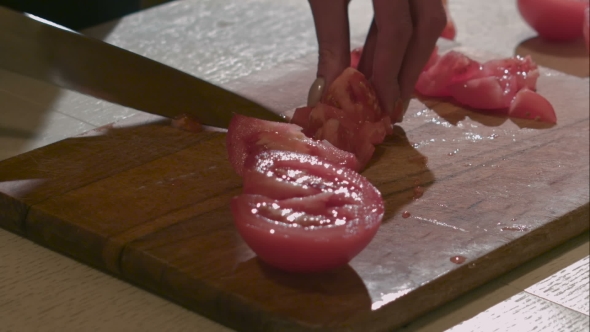 Female Hands Chops Tomato By The Knife