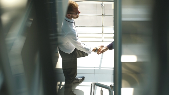 Handshake Of Business Partners Met On The Stairs In The Office Building