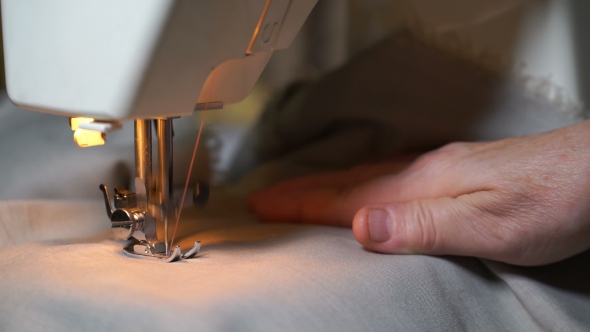 Woman Sews On The Sewing Machine