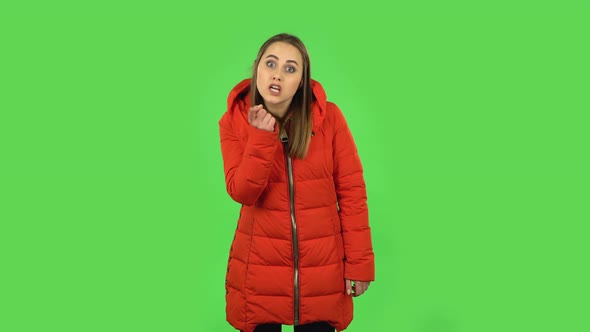 Lovely Girl in a Red Down Jacket Is Scolding, Shaking Her Index Finger and Threatening. Green Screen