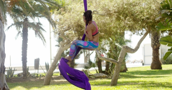 Female Acrobat Working Outdoors On Silk Ribbons