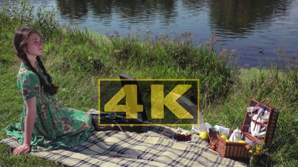 Young Girl On Picnic On The Banks Of The River Listening To The Record On Vintage Gramophone