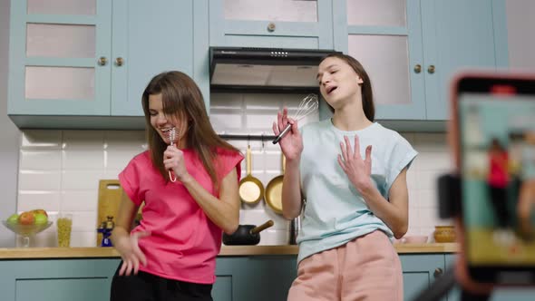 Two Young Girls Dancing Sing and Filming Videos for Their Blogs or Social Networks