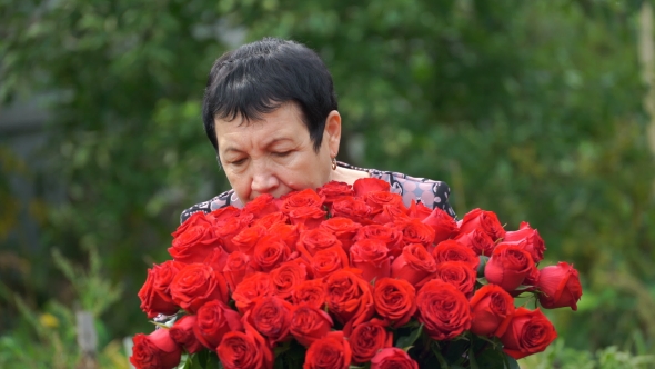 Footage Elderly Woman Holding a Bouquet Of Roses Outdoors.