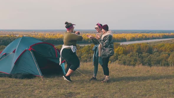 Plump Woman Dances with Friends By Tent at River Slow Motion