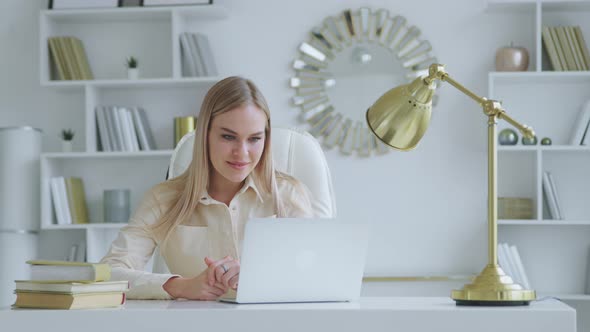 Beautiful woman talking on live video with colleagues using laptop