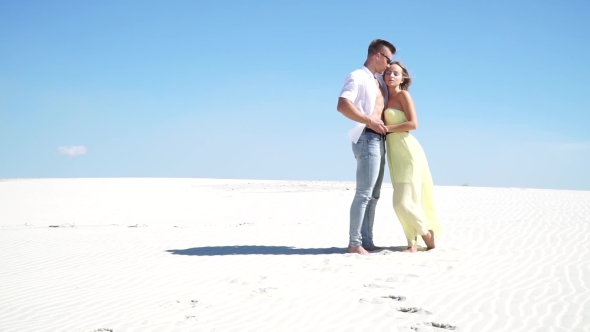 Loving Couple Embracing In The Desert In The Wind