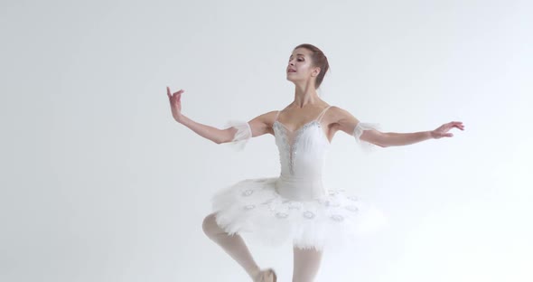 Elegant Female in a White Tutu Dance Ballet and Perform Choreographic Elements on a White Background