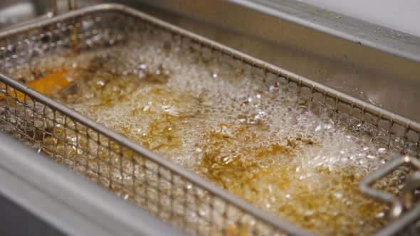 Slices of Potatoes Rustic Is Frying in Hot Boiling Oil at Cuisine