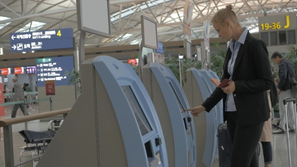 Woman Using Self-service Machine To Check-in