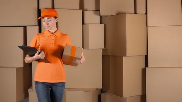 Pretty Female Courier in Orange Uniform Delivering a Parcel