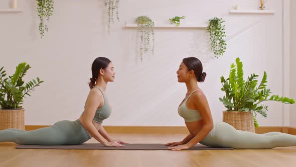 Calm of wellness Couple Asian young woman sit on yoga mat doing breathing exercise yoga cobra pose t