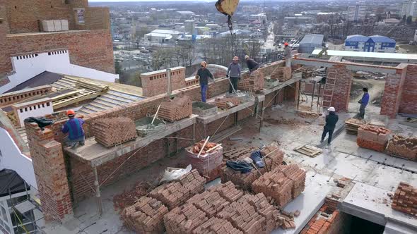 Construction Workers Working on a Building Site of New Residential Building