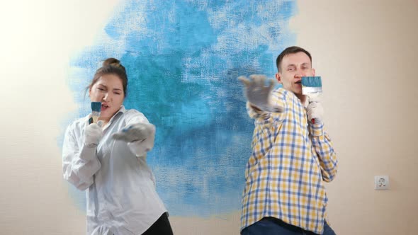 Amazed Couple Dances Pretends Singing Into Brushes As Mics