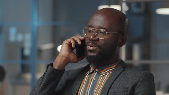 African American Businessman Talking on Phone in Office at Night