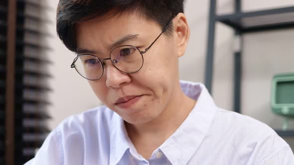 Asian lesbian women with short hair Wearing glasses, she has a lot of stress.