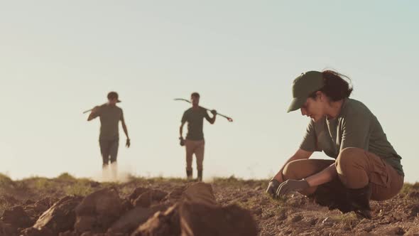 Mixed-race Women Pulling out Weeds in the Evening