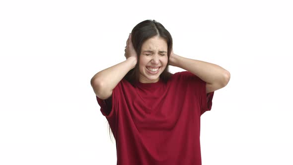 Young Brunette Woman in Red Tshirt Shutting Her Ears and Shaking Head From Annoying Noise Feeling