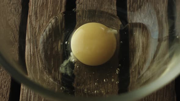 Slow motion of egg yolk falling in bowl