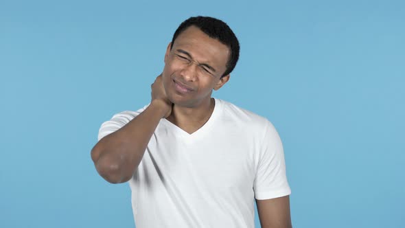 Young African Man with Neck Pain, Blue Background