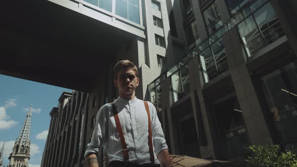 Man Looking to Camera While Standing Outdoors Business Building on the Background