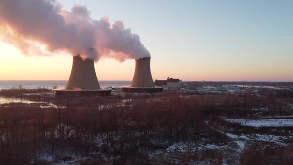 Dolly Right Aerial Drone Shot of Nuclear Power Plant Cooling Towers at Sunrise Sunset with Steam and