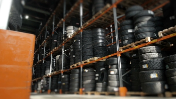 Car Tires At Warehouse In Tire Store. A Huge Warehouse Of a Car Tires Stored On Shelves alt