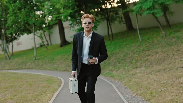 Businessman with Coffee and Suitcase on Longboard