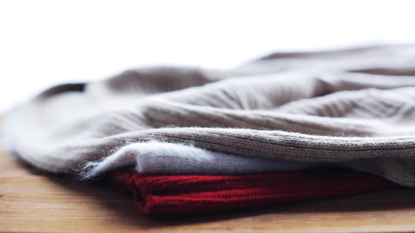 Knitwear Or Woolen Clothes On Wooden Table At Home