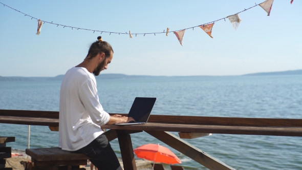 Man Looking For Information In The Laptop On The Waterfront On Sea Background