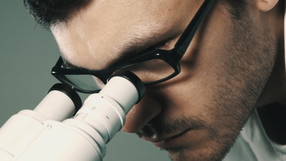 Young Scientist Looking Through The Microscope alt