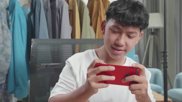 Close Up Of Asian Man Online Seller Taking Photos With Mobile Phone While Using Computer For Selling