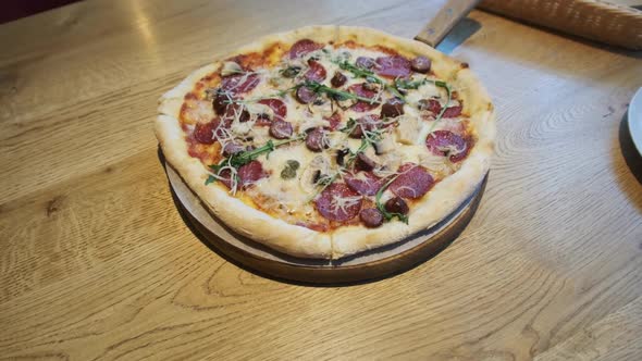 Freshly Prepared Pizza on a Wooden Table in a Cafe