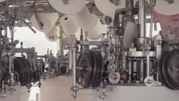 Worker working at a circular knitting machine in knitting factory