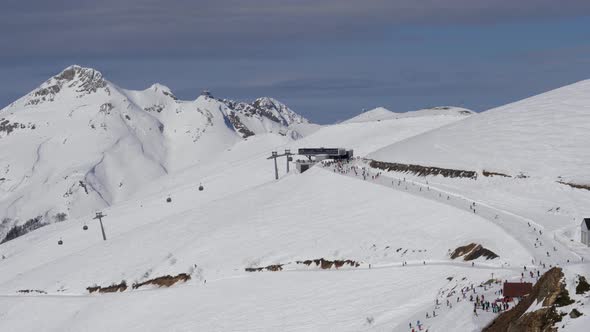 Skiers And Snowboarders Skiing Down Snowy Ski Slope In Snow Mountains In Winter