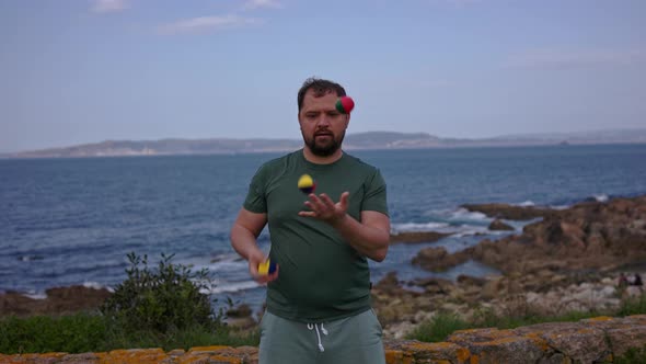 A Man Juggles on the Beach