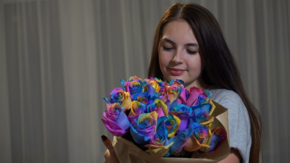 Young Woman Is Smelling Bouquet Of Rainbow Roses