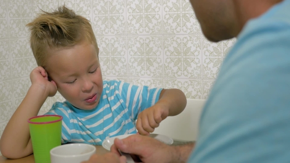 Son Speaking With Father And Eat Using a Spoon And Smiling