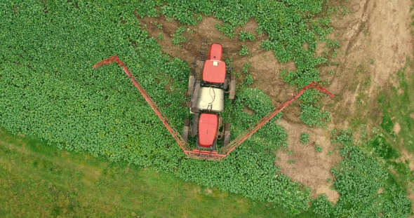 Aerial Shot Tractor Sprayers Lays On The Field With a Canola