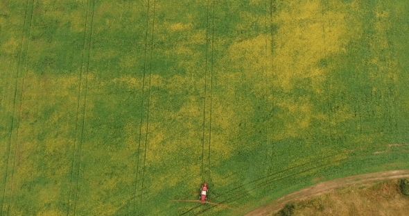 Aerial Shot Tractor Sprayers Lays on the Field With a Canola