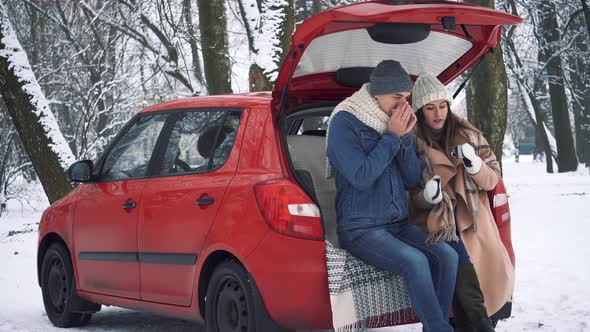 Tea party in car trunk - loving couple sits in car trunk in Valentine's day