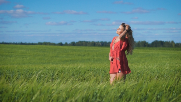 Charming Blonde Woman At a Green Field