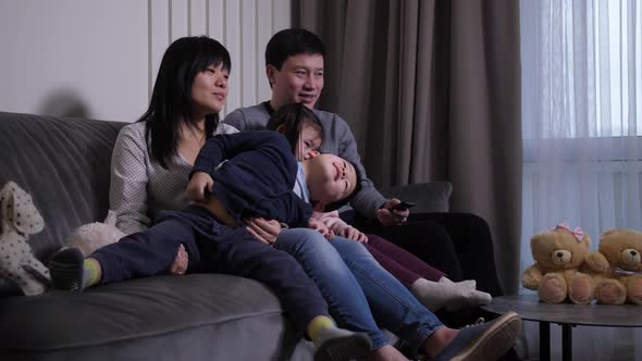 Happy Chinese Family with Kids Watching TV at Home